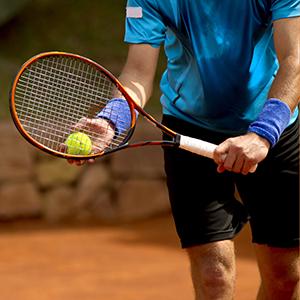 Tennis player gets ready to hit ball with racket